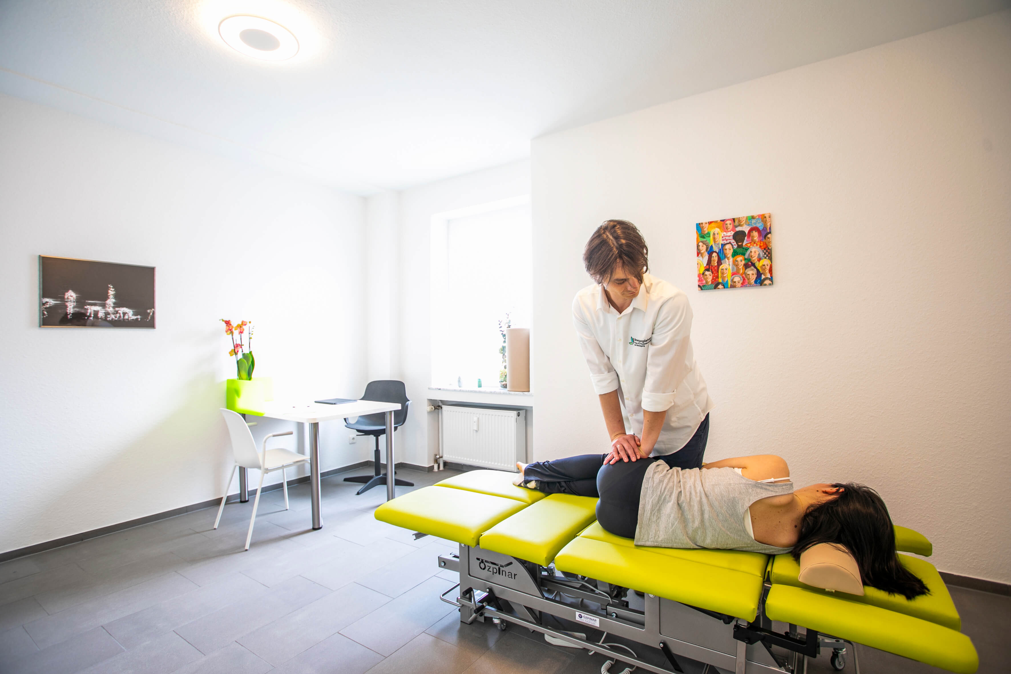 Deniz Cakir behandelt eine Patientin in seiner Praxis für Physiotherapie und Bewegung, Bewegungsfarben.